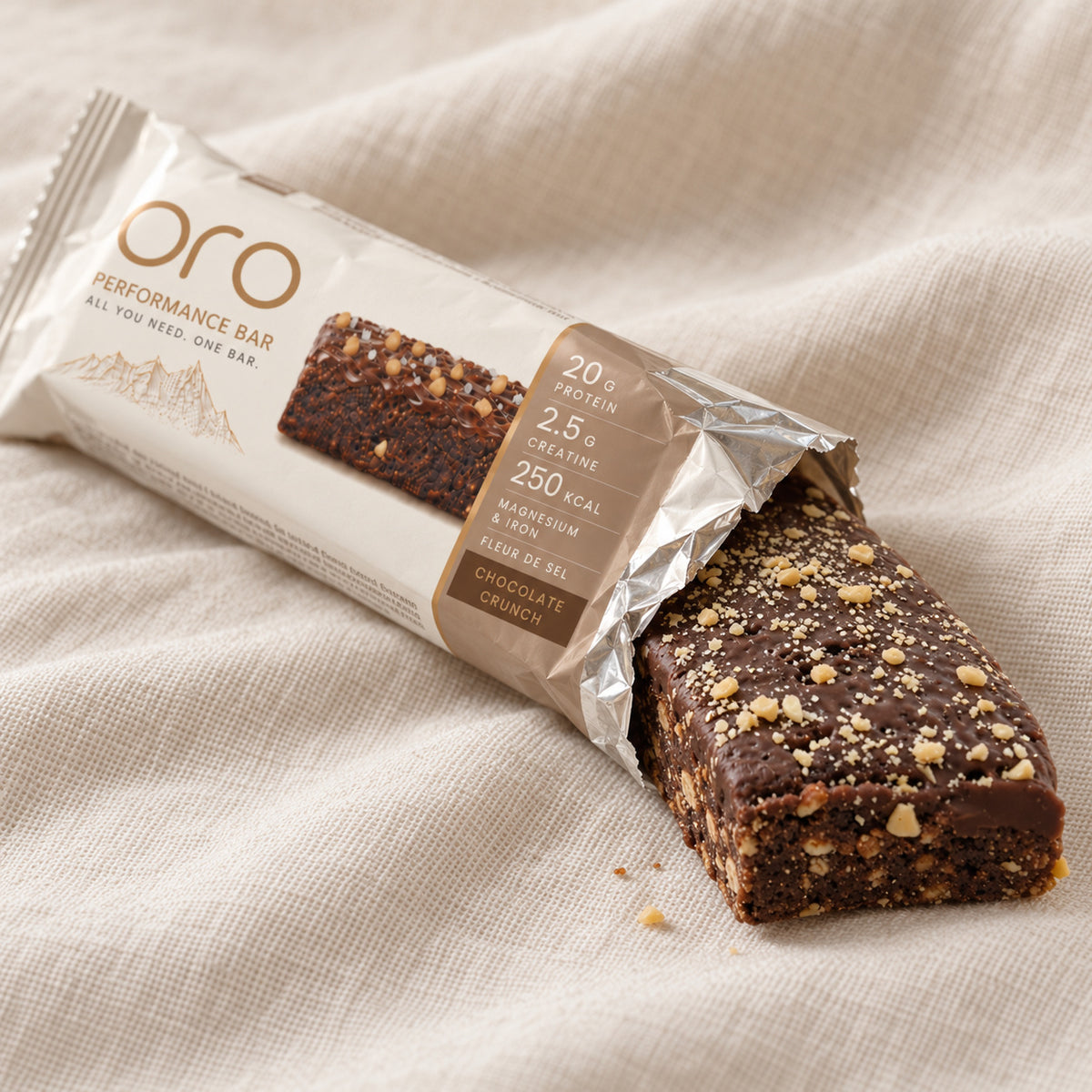 Opened ORO wrapper on a cream cloth, the Chocolate Crunch bar sliding out