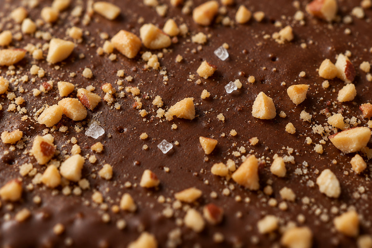 Close-up of the ORO bar top: cocoa coating, chopped peanuts and fleur de sel
